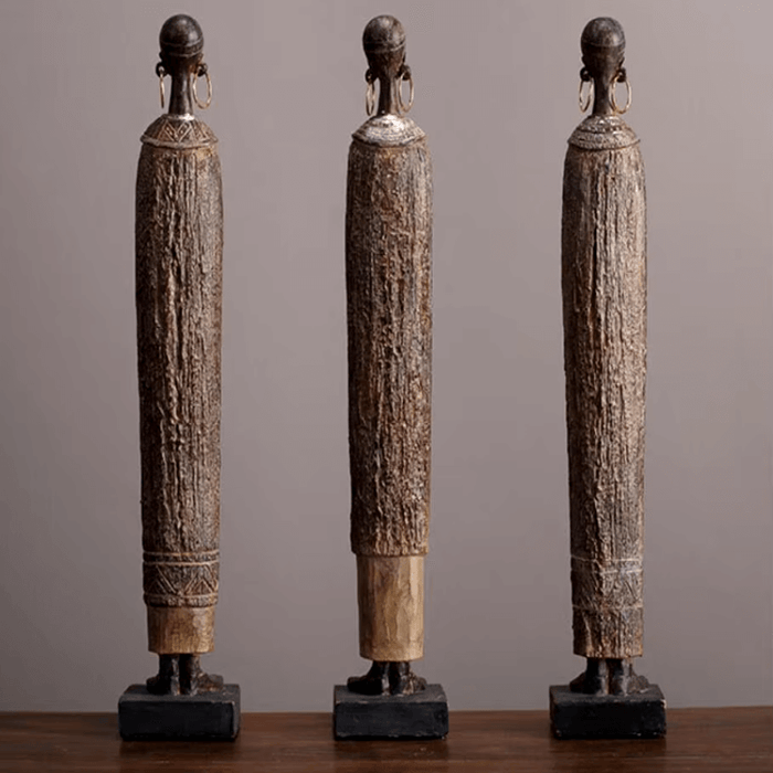 African style standing woman statues with textured patterns on a table, showcasing cultural elegance and intricate artistry.