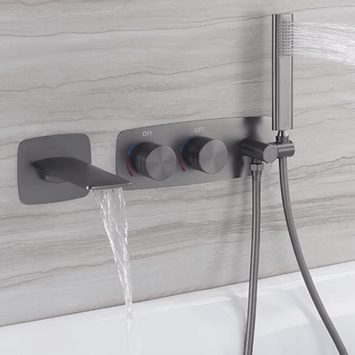 Gunmetal dual-handle waterfall bath faucet with handshower holder mounted on a modern wall, creating a sleek bathroom look.