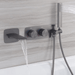 Gunmetal dual-handle waterfall bath faucet with handshower holder mounted on a modern wall, creating a sleek bathroom look.