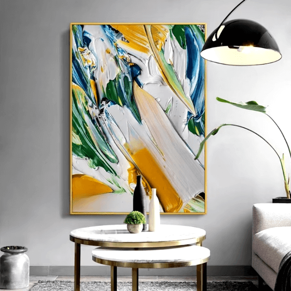 Abstract canvas art with vivid strokes in yellow, blue, and green displayed in a modern living room setting.